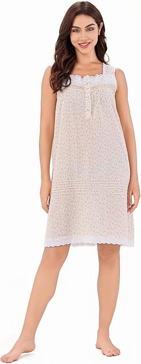 A woman standing and posing in a floral sleeveless cotton sleepwear dress above the knee.